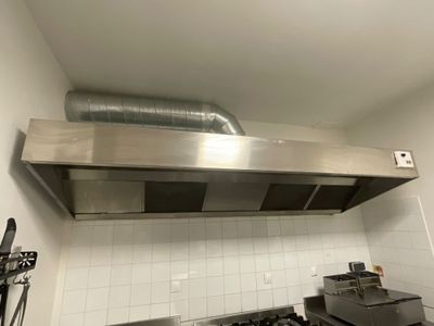 a stainless steel range hood in a kitchen with a stove