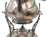 une théière en argent posée sur un socle, sur fond blanc