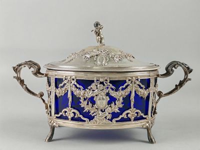 an ornate silver and blue glass covered dish with a bird on top