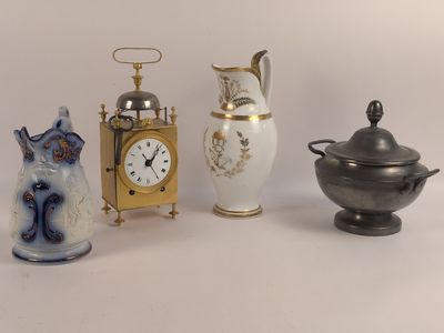 trois types de vases différents et une horloge posés sur une table