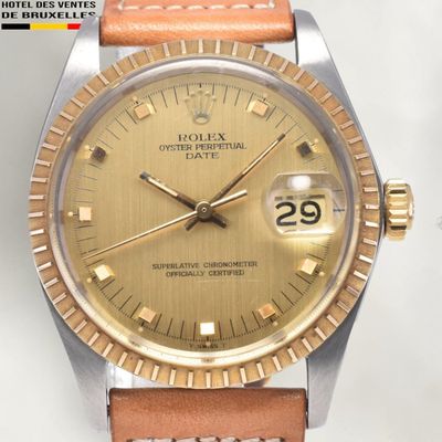 an image of a watch with a gold dial on a tan leather strap