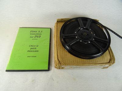 une bobine de cassette posée sur une boîte à côté d'un DVD