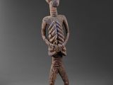 une figurine en bois représentant un squelette avec une tête et des bras de squelette