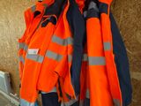 de nombreuses vestes orange accrochées à un mur dans une pièce