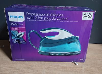 emballage d'un fer à repasser à vapeur bleu et blanc posé sur une table en bois