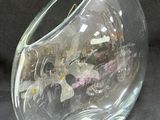a glass vase with flowers inside of it on a black surface