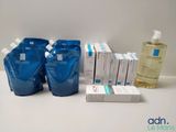 four bottles of water and a box of soap on a table