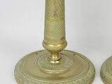 pair of antique brass candlesticks with intricate designs on the bases
