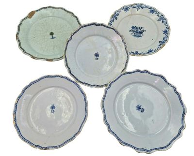 four plates with blue and white designs on them on a white surface