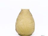 un vase jaune posé sur une surface blanche