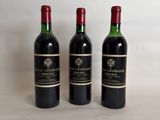three bottles of wine sitting on top of a white table