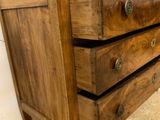 a small wooden chest of drawers on the floor