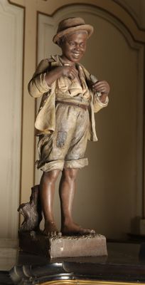 a statue of a boy with a hat on a table