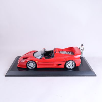 une voiture de sport Ferrari rouge posée sur un socle noir, avec un fond blanc