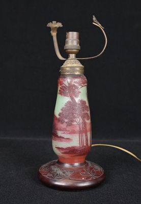 an old fashioned lamp with a red and green design on it