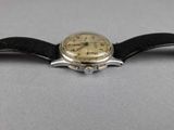 a close up of a watch on a black leather strap