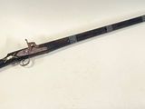 an old gun with a wooden handle on a white surface