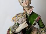 a figurine of a woman holding a fan and a fan