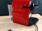 une petite machine à café rouge posée sur une table en bois