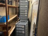 une pile de caisses dans une pièce étroite équipée d'étagères