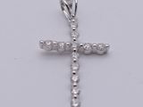 a diamond cross pendant on a white background