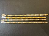 three pieces of gold colored metal bracelets on a black surface