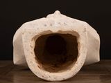 a close up of a white vase on a wooden table