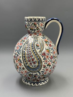 un gros plan d'un vase posé sur une table, sur fond gris