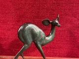 une statue représentant un cerf debout sur un socle rouge