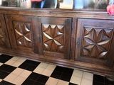 une armoire en bois surmontée d'un miroir, dans une pièce