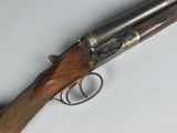 an old gun with a wooden handle on a white surface