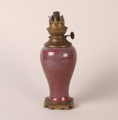 un vase rouge surmonté d'une couronne