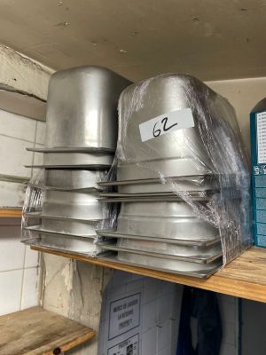 several pans are stacked on a shelf in a kitchen