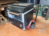 une machine posée par terre à côté d'un tas de bois