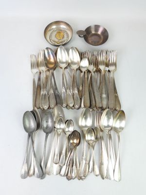de nombreuses cuillères en argent et des cuillères disposées sur une table