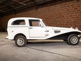 a white car parked in a garage with a brick wall in the background