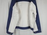 a white and blue jacket hanging on a white curtain