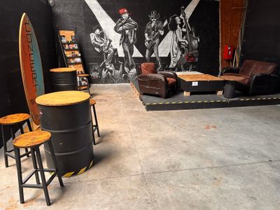 a room that has a lot of furniture and a surfboard on the wall