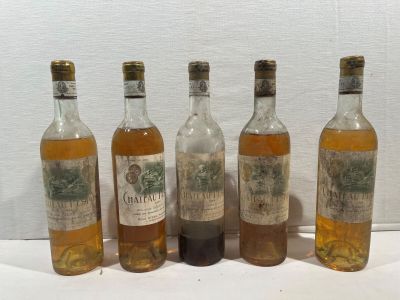 six bouteilles d'alcool sont alignées sur une table