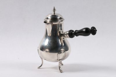 une cafetière ancienne en argent avec une poignée noire sur fond blanc