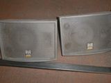 pair of two speakers sitting on top of a table next to a lamp
