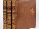 trois vieux livres posés l'un sur l'autre sur une surface blanche