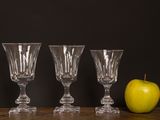three empty wine glasses and an apple sit on a table