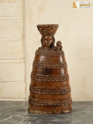 a wooden sculpture of a woman holding a basket on top of her head