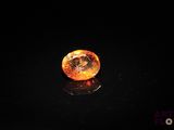 gros plan d'un diamant orange sur une surface noire