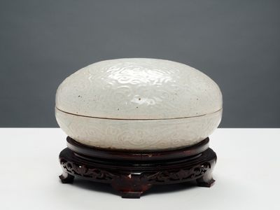 un bol blanc posé sur un socle en bois