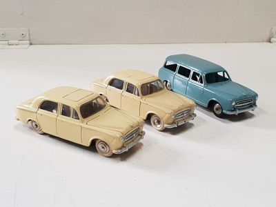 three toy cars sitting next to each other on a white surface