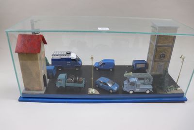 une vitrine en verre contenant de nombreuses petites voitures