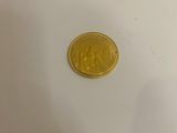 a close up of a gold coin on a white surface