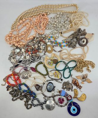 a pile of assorted necklaces and bracelets on a white surface